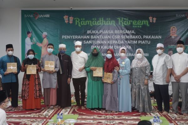 Direktur Utama Bank Jambi Dr. H. Yunsak El Halcon, SH., M.Si foto bersama dengan anak yatim piatu yang menerima santunan sembako dari Bank Jambi.